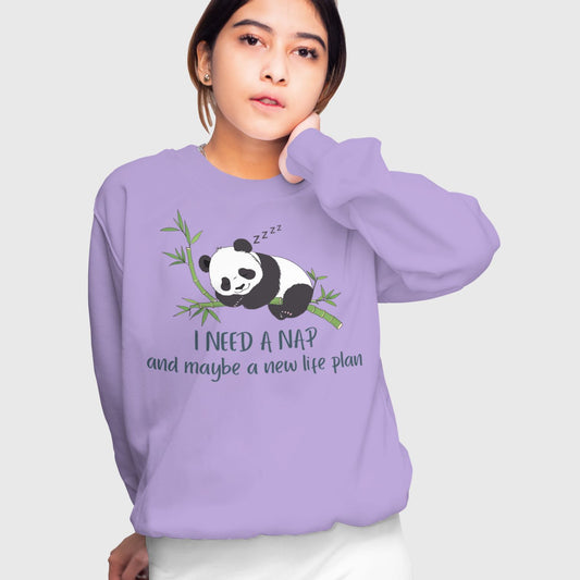 Person lounging in a funny sweatshirt reading “I Need a Nap & a Life Plan” – perfect for the just-five-more-minutes crew.