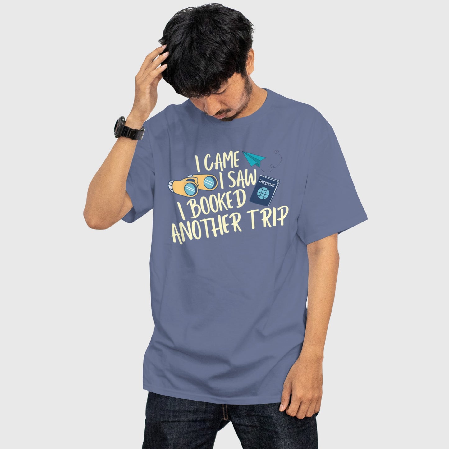 Man wearing blue travel t-shirt with quote “I Came, I Saw, I Booked Another Trip”