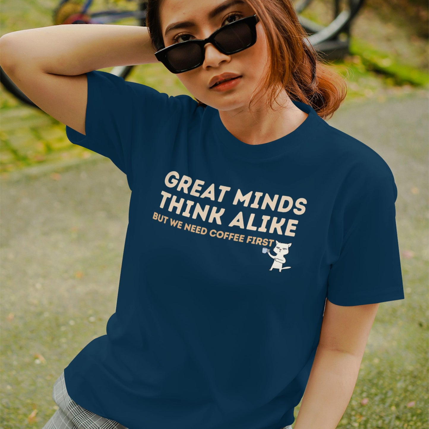 Person wearing a navy blue coffee-themed graphic T-shirt with a funny quote and cute cat design.
