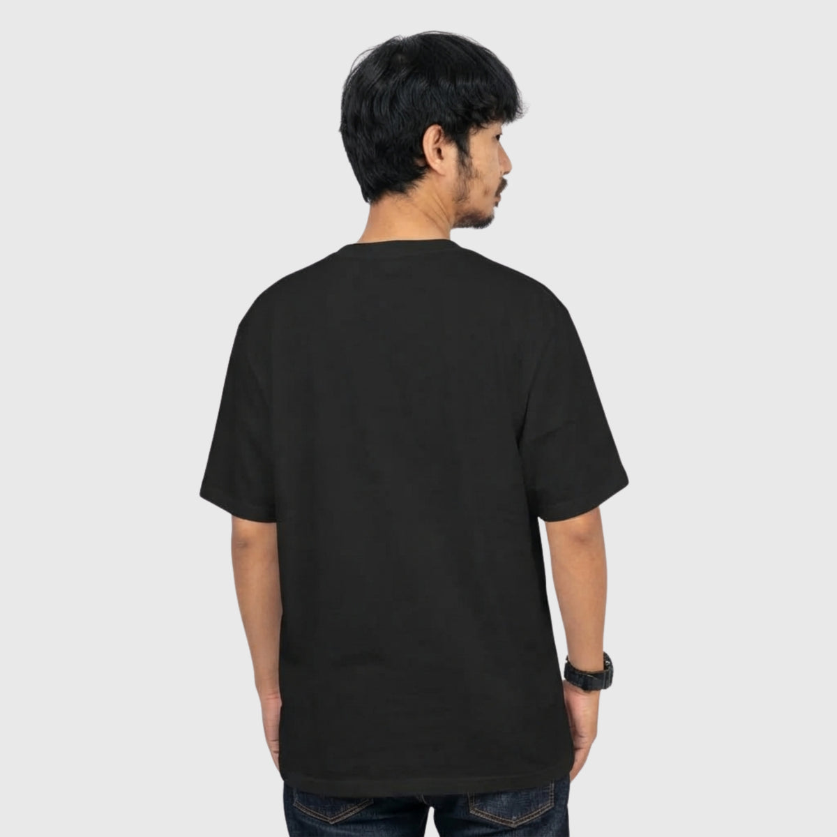 back side of a Model wearing a black oversized T-shirt with a subtle, sarcastic environmental humor design