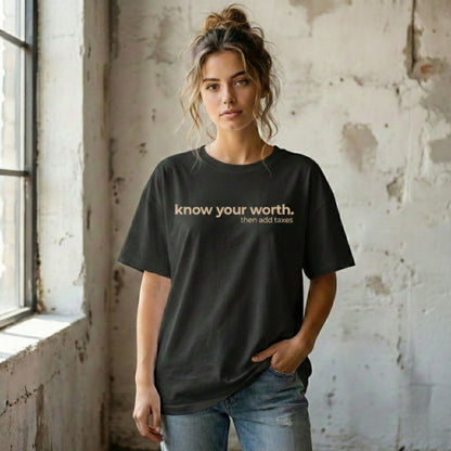 Woman wearing a black unisex funny sarcastic t-shirt with the quote “know your worth then add taxes,” minimalist graphic tee style.