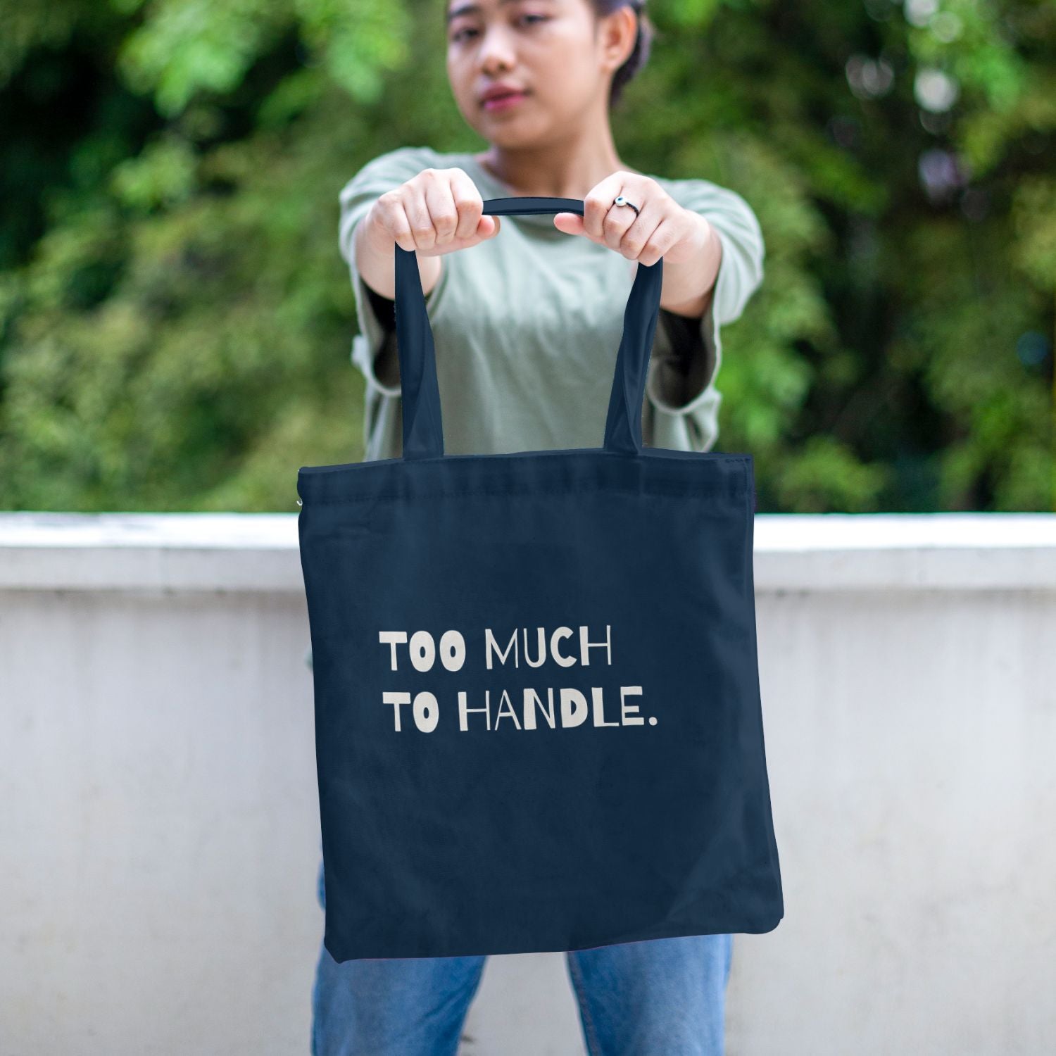 Navy canvas tote bag featuring a bold cream typography design